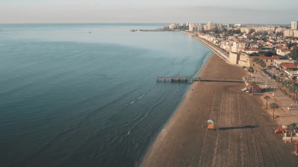 Vista aérea de la ciudad playa de arena cerca del mar azul. Hermoso paisaje urbano junto al océano. Viaje de verano en una isla. — Vídeos de Stock