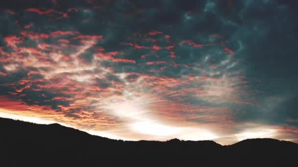 Воздушный Закат в бурных облаках над горами. Драматическое черное и красное небо над темным вечерним лесом. — стоковое видео