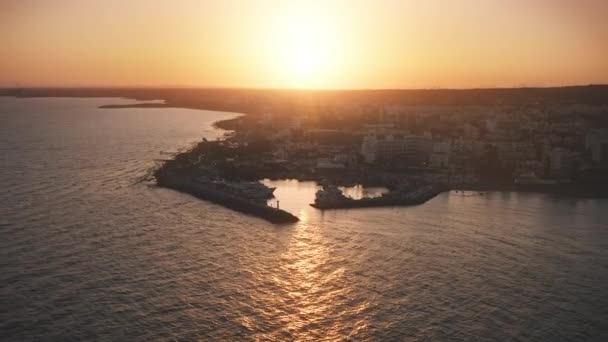 Vista aerea, tramonto arancione sulle navi marina vicino alla città. Città costiera panoramica vicino all'acqua di mare. — Video Stock