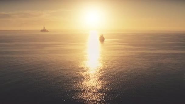 Vista aérea, transporte de carga, barcos en alta mar. Luz suave puesta de sol. Sol amarillo brillante, horizonte — Vídeo de stock