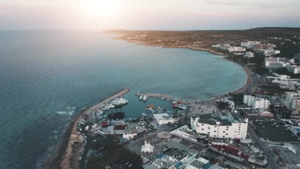 Resort dal mare blu, spiaggia paesaggio urbano Ayia Napa. All'alba. Raggio di sole rosa, cielo lilla. Ondulazione. Isola — Video Stock