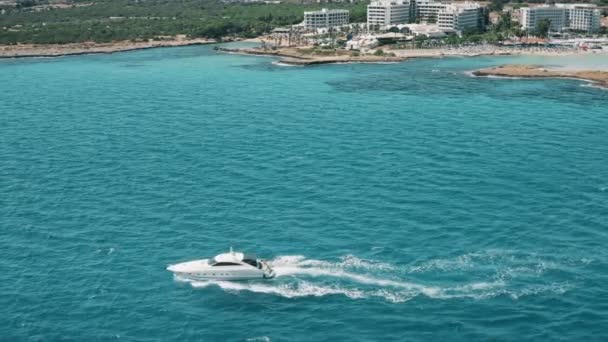 Yate blanco barco de vela viaje en aguas azules en la ciudad balneario en Ayia Napa, Chipre — Vídeo de stock