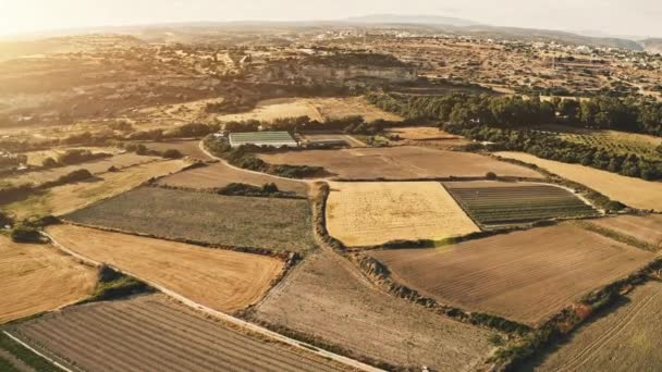 Вид с воздуха на закат на желтых полях сбора урожая в сельской местности горной местности на Кипре — стоковое видео