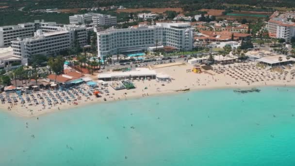 Panorama seaside resort town with people sunbath on Nissi Beach in Ayia Napa in Cyprus — стокове відео