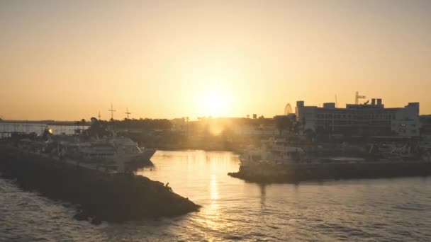 Statki pasażerskie są na drogach na morzu, żółty zachód słońca. Cinematic niebo nad portowym wieczorem miasta. — Wideo stockowe