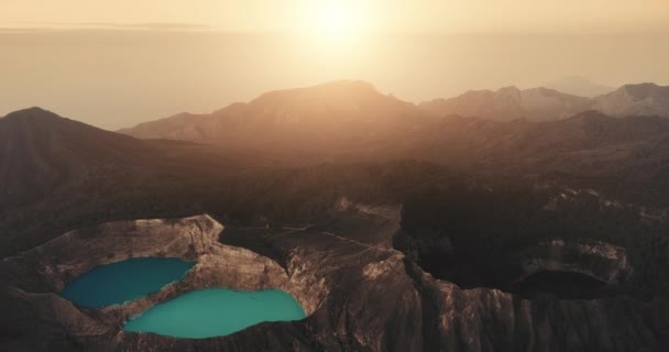 Hermosa puesta de sol naranja sobre el monte volcánico Kelimutu, formaciones rocosas marrones en Indonesia — Vídeos de Stock