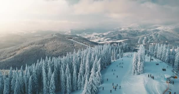 Sonniger Tag im schneebedeckten Winterferienort mit Touristen Skifahren in Bukovel, Ukraine — Stockvideo