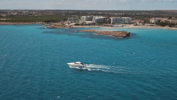 Iahtul alb de lux cu motor navighează spre marea albastră lângă laguna de pe țărmul insulei. Tropical resort city city city — Videoclip de stoc