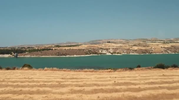 Campos de colheita amarelos perto do lago azul do rio no campo paisagem área selvagem rural em Chipre — Vídeo de Stock