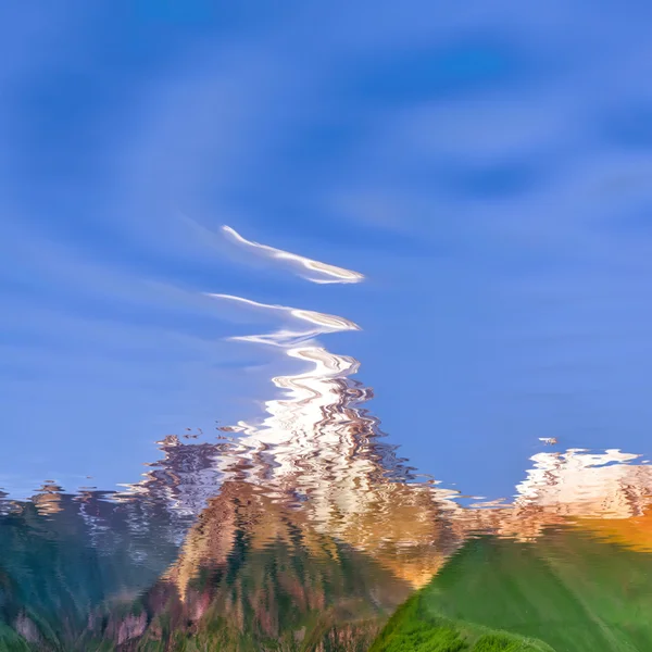 Sky and mountains reflected in water — Stock Photo, Image