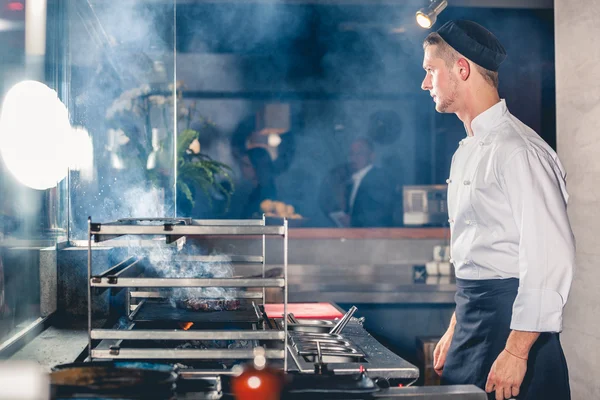 Männlicher Koch bereitet Essen auf dem Grill zu — Stockfoto