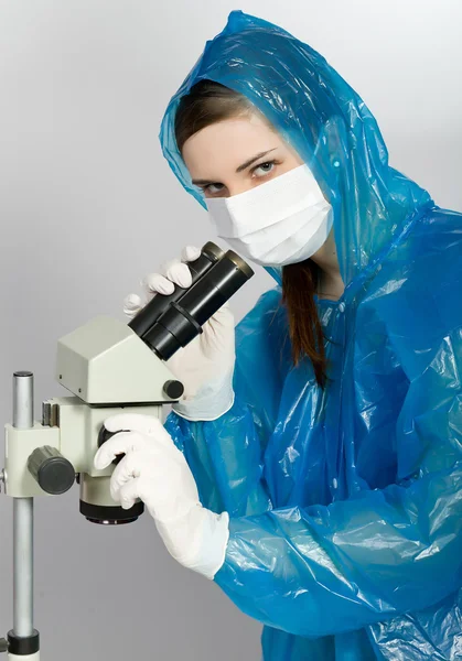 Дівчина дивиться через мікроскоп — стокове фото