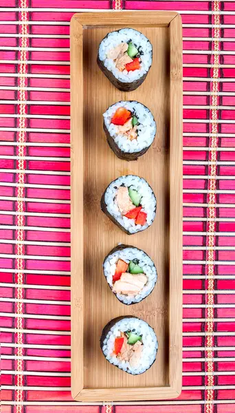 Sushi na dřevěný talíř a bambusové rohože — Stock fotografie