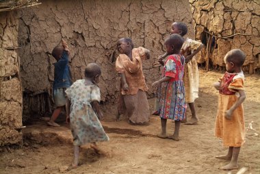 Masai Mara, Kenya - 23 Ağustos 2010: Kenya 'nın en ünlü ulusal yedek parklarından biri olan Masai Mara' daki köylerinde gösterilen basit ve kirli giysileri olan Masai kabilesinden oyuncu çocuklar