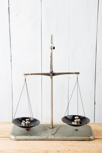 Balance scales on white wooden background — Stock Photo, Image