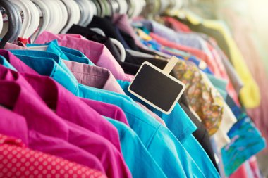 Giysiler moda mağazasında askıda asılı.