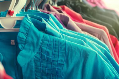 Giysiler moda mağazasında askıda asılı.