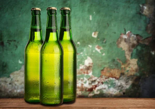 Група пляшок холодного вологого пива на гранжевому фоні — стокове фото