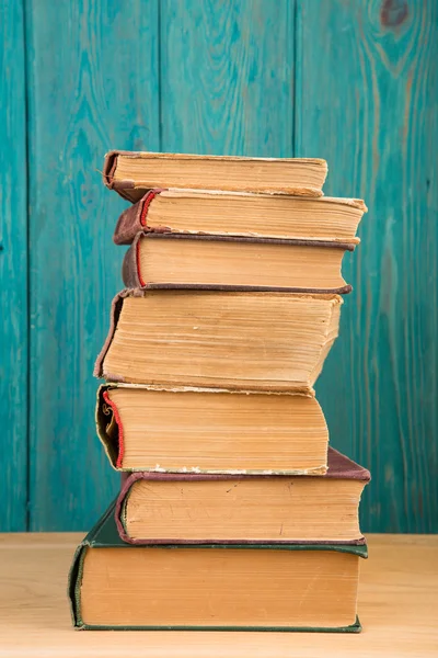 Pilha de livros na mesa sobre fundo de madeira — Fotografia de Stock