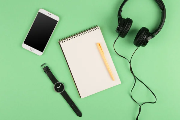 Smartphone, bloc de notas, auriculares, bolígrafo y reloj — Foto de Stock