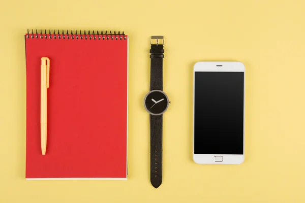 Телефон, блокнот, часы и ручка на цветном фоне — стоковое фото
