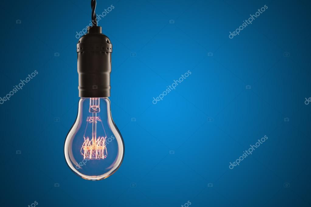 Vintage incandescent Edison type bulb on wooden background Stock Photo