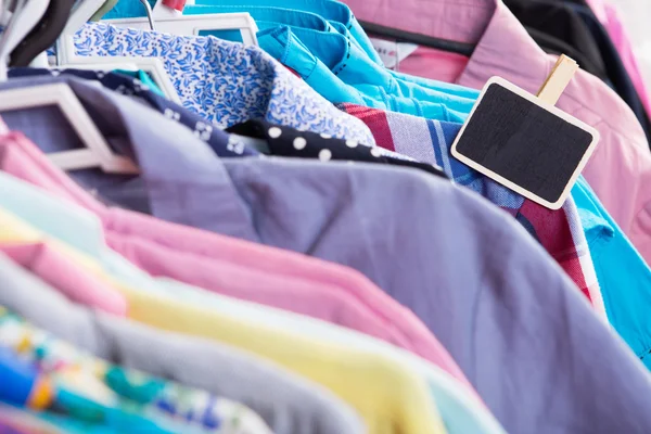 Clothes hanging on the rack in the store — Stock Photo, Image