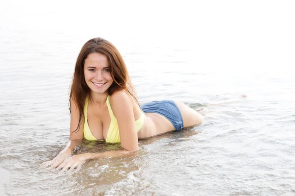 Ung sexig kvinna i en baddräkt i havet bevattnar — Stockfoto