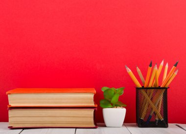Eğitim ve bilgelik kavramı - ahşap masa üzerinde açık kitap, kırmızı arkaplan