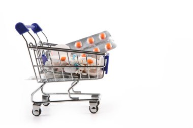 Haplar ve kapsüllerle dolu izole bir alışveriş arabası.