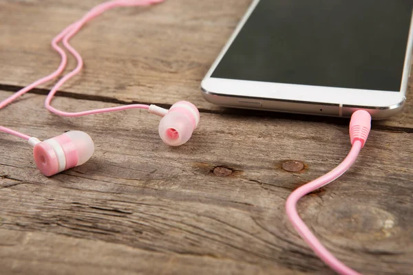 Smartphone Blanco Con Auriculares Rosados Tablero Madera Viejo — Foto de Stock