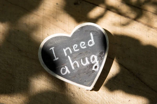 I need a hug - hand drawing phrase on a heart, Sharing a Hug concept