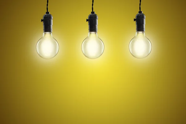 Идея концепции - Винтажные лампы накаливания на желтом фоне — стоковое фото