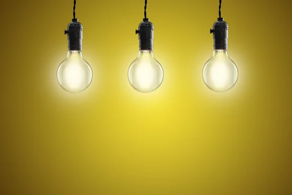 Idea concept - Lampadine a incandescenza vintage su sfondo giallo — Foto Stock