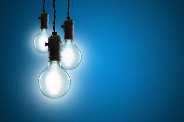 Idea concept - Vintage incandescent bulbs on blue background — Stock Photo, Image