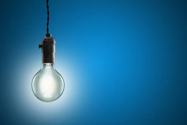 Idea concept - Vintage incandescent bulb on blue background — Stock Photo, Image