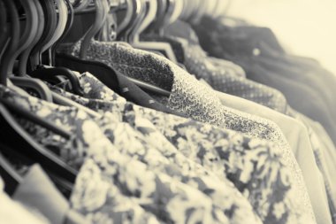 Giysiler tasarımcı giyim mağazasının rafında asılı.