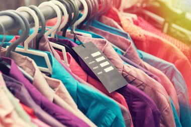 Boş fiyat etiketi giysilerindeki asmak bir raf bir moda mağazası 