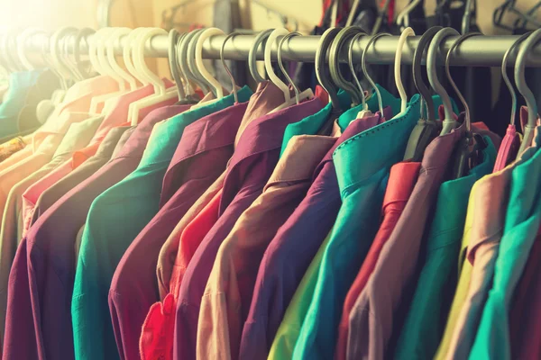 Ubrania wiszą na półce w sklepie z ubraniami. — Zdjęcie stockowe