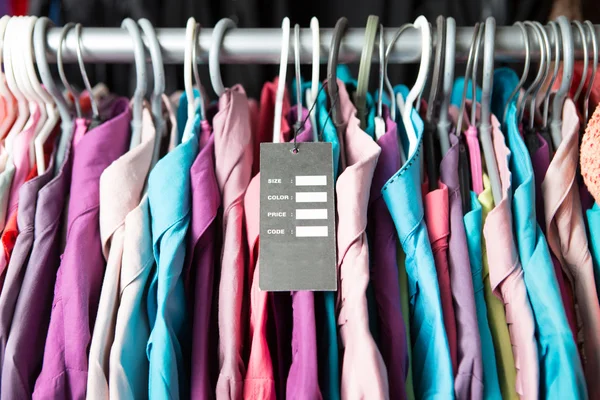 Puste cena etykieta na ubrania powiesić na półce w sklepie moda — Zdjęcie stockowe