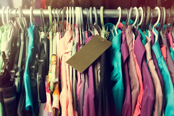 Blank price label on clothes hang on a shelf in a fashion store — Stock Photo, Image