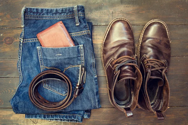 Джинсы, ремень, обувь и бумажник на деревянном фоне — стоковое фото