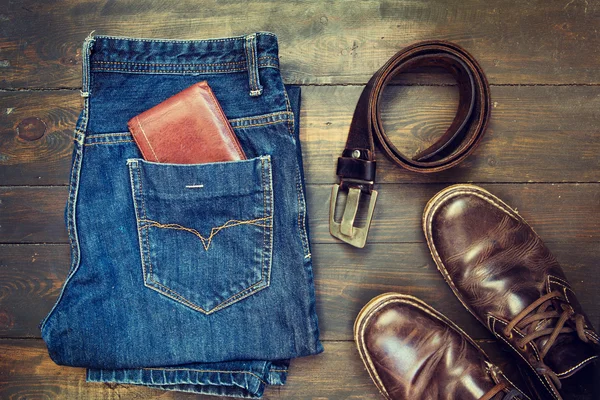 Jeans, cinto, sapatos e carteira sobre fundo de madeira — Fotografia de Stock