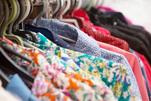 Clothes hang on a shelf in a designer clothes store — Stock Photo, Image