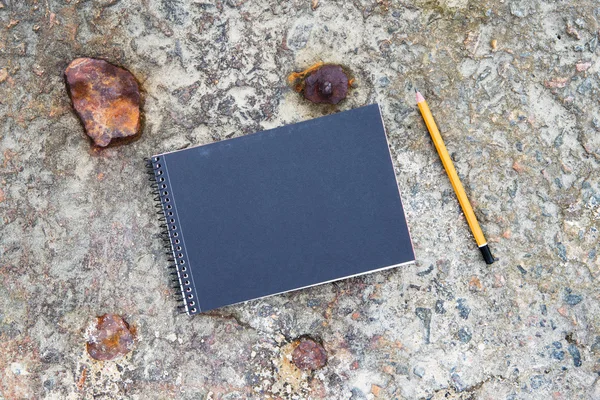 Notepad and pencil on the concrete floor — Stock Photo, Image