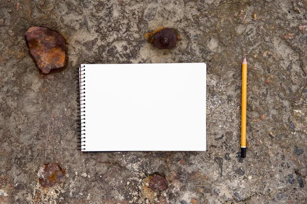 Blocco note e matita sul pavimento di cemento — Foto Stock