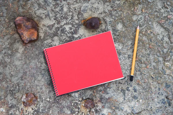 Notepad and pencil on the concrete floor — Stock Photo, Image