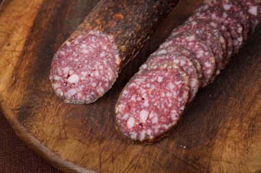 ahşap tahta üzerinde dilimlenmiş salam