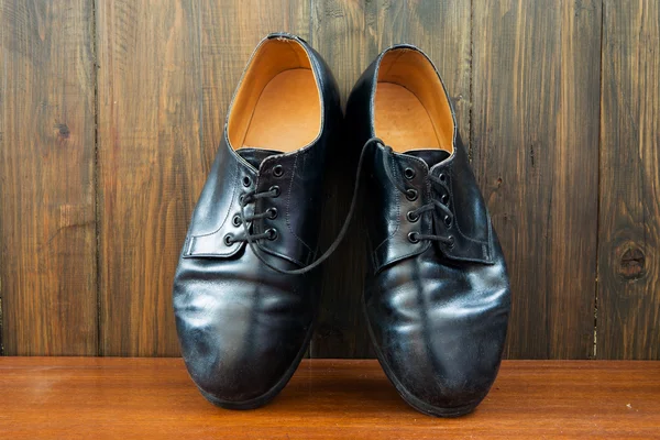 Chaussures noires sur le fond en bois — Photo