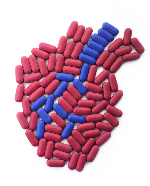 Coração humano de comprimidos vermelhos e azuis — Fotografia de Stock